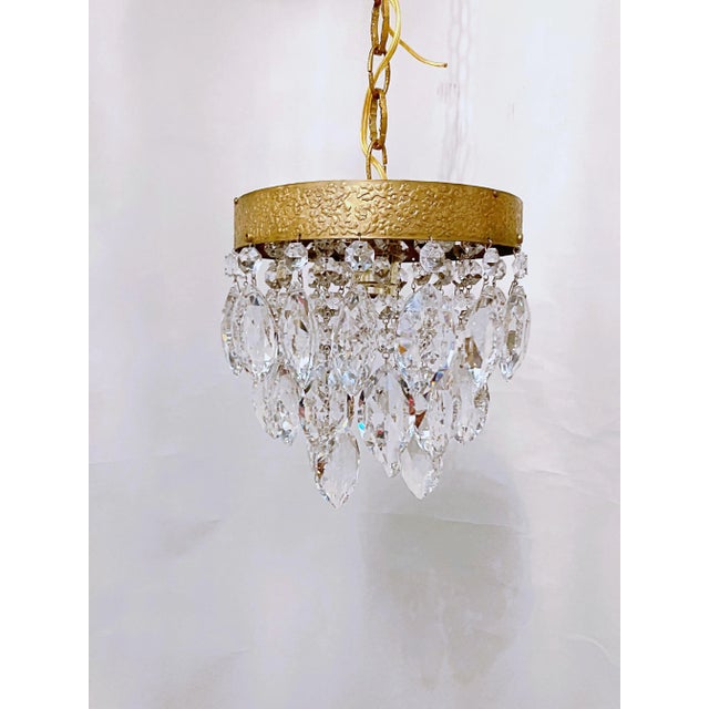 This is a 1960's chandelier with decorative brass rim draped with octagon bead chain and double pint diamond cut crustal...