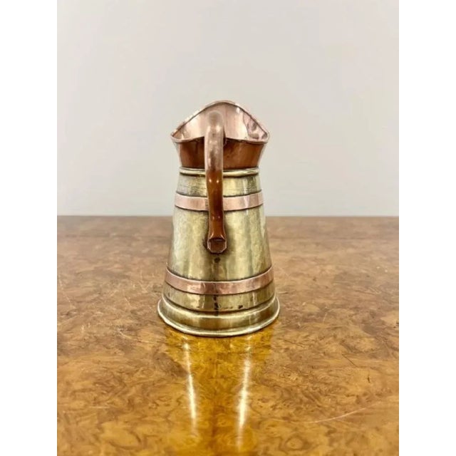 Antique Edwardian quality brass and copper jug having a quality shaped copper handle and copper bounds around a brass...
