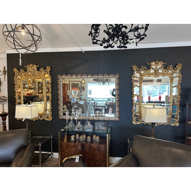 Monumental pair of breathtakingly dramatic Hollywood Regency giltwood mirrors having ornate frames with mirror...