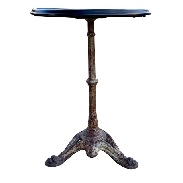 Circular ebonized top on a cast iron base with dolphin feet.