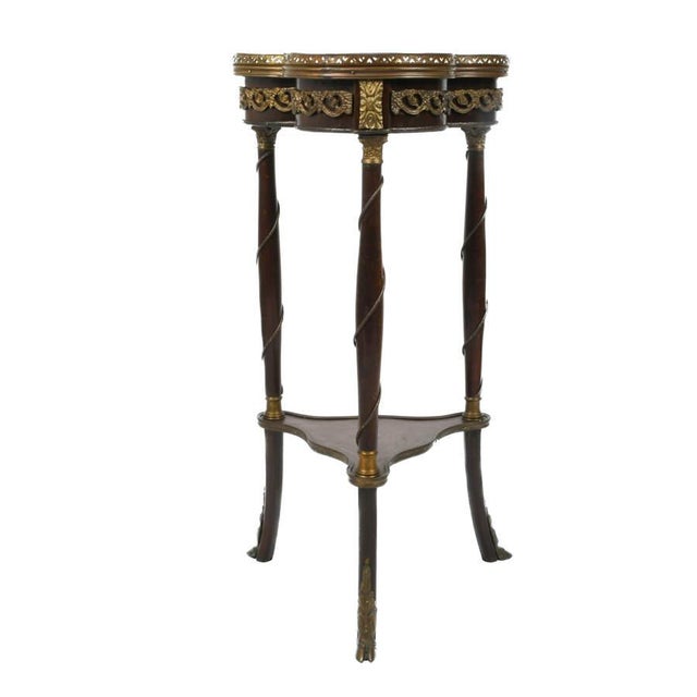 An Antique Late 19th Century Louis XV-Style Marquetry Side Table is a decorative piece of furniture crafted in the elegant...