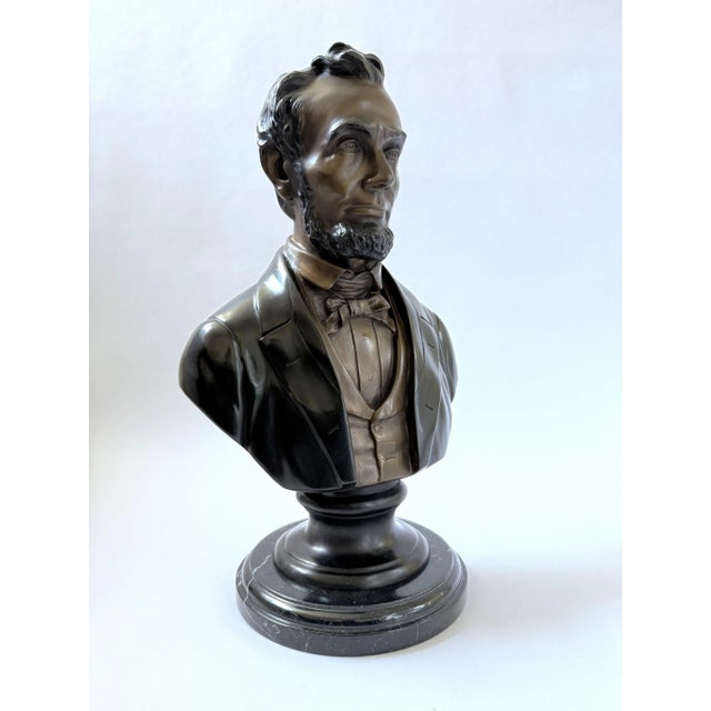 A finely modeled bronze bust of Abraham Lincoln, depicted with his characteristic solemn expression and iconic beard. The...
