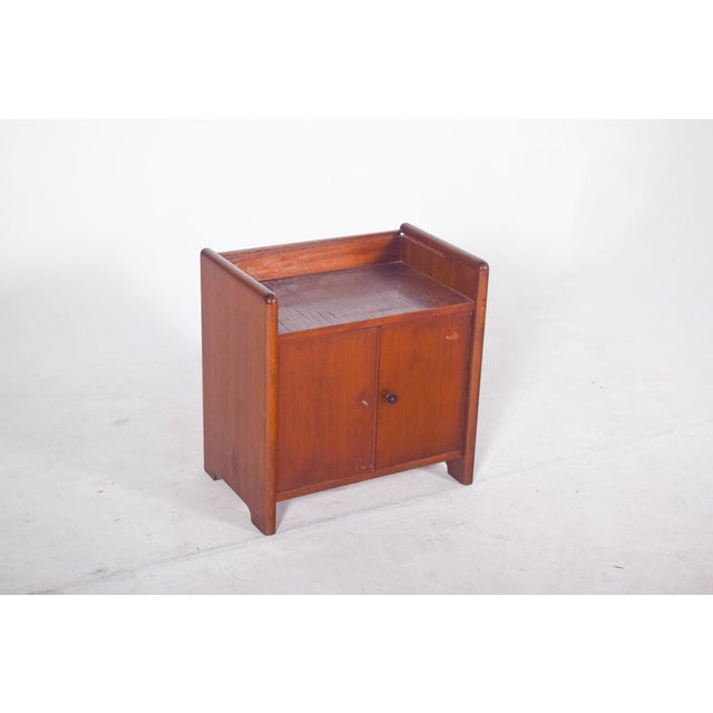 Teak bar cabinet. With a compact and functional design, the cabinet has a rectangular structure with rounded sides and a...