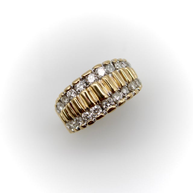 This striking 1970’s or 1980’s diamond ring has beautiful craftsmanship with a row of diamonds along the top and bottom of...