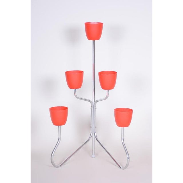 This flower stand with a frame of bent steel tube and plastic flower pots, was made in the 1950s in the Czech Republic....