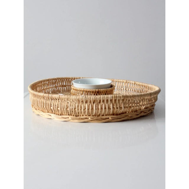 A vintage woven serving tray with integrated center bowl. this large wicker tray features a lipped edge and a divided...