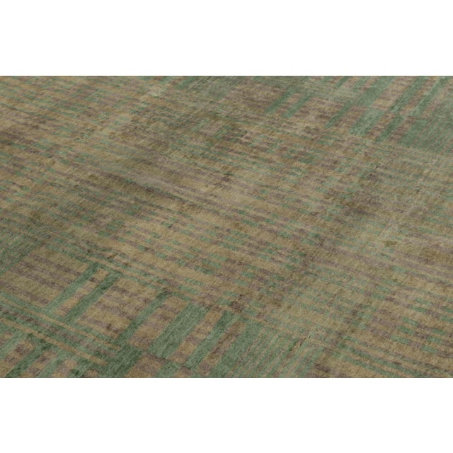 This 8x10 rug, hand-knotted in mohair, features a softly geometric plaid in muted sage, flax, taupe, and gray. Its...