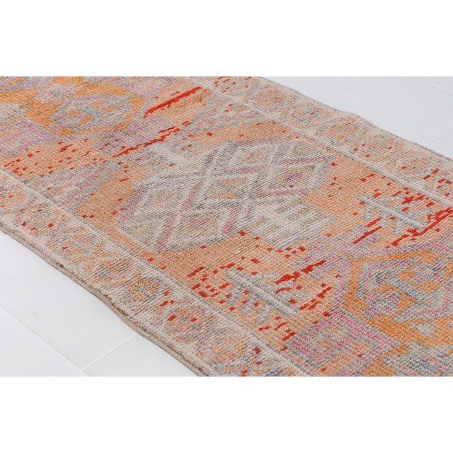 This is a vintage Turkish Oushak rug from the Mid 20th Century. The piece was hand-knotted.