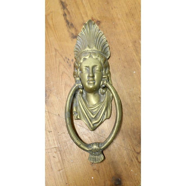A Victorian Brass Caryatid Door Knocker A Large Victorian Brass door knocker decorated with the face of a caryatid wearing...