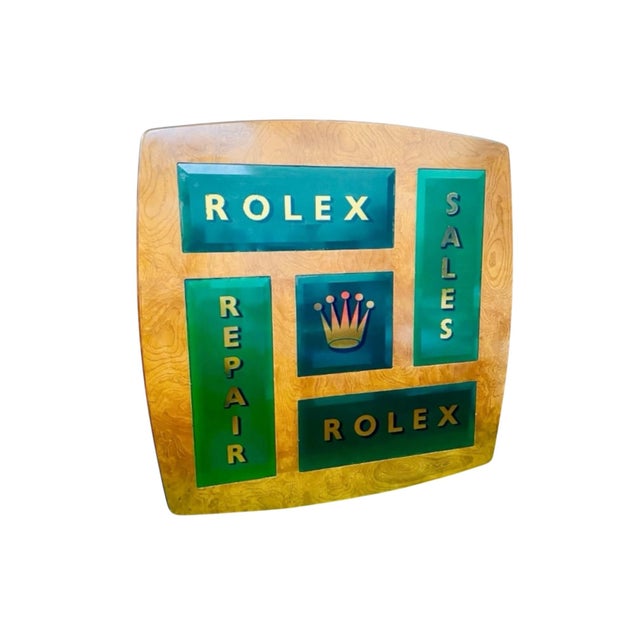 A large-scale mid-century wooden shop sign dating from the 1950s, featuring gilt-lettered glass panels reading “Rolex”,...