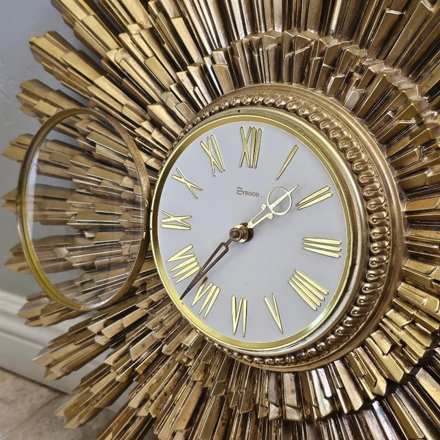 Mid-century Syroco Starburst wall clock, circa 1969. This stylish piece is made of cast plastic in an antique gold finish....