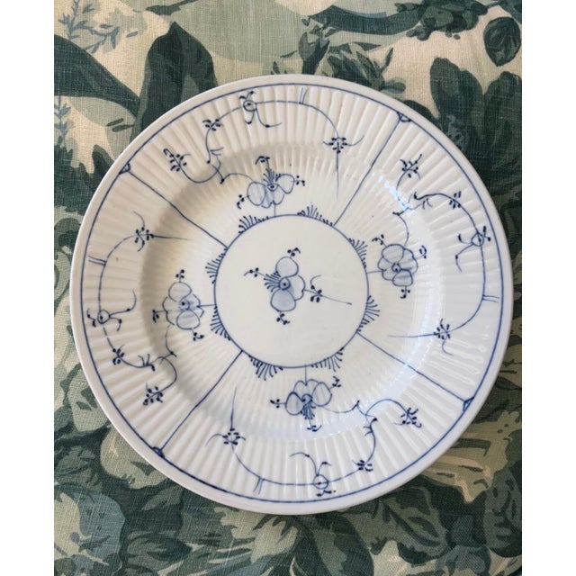 A charming antique German porcelain plate with fluted body and decorated in cobalt blue stylized flowers, scrolling...