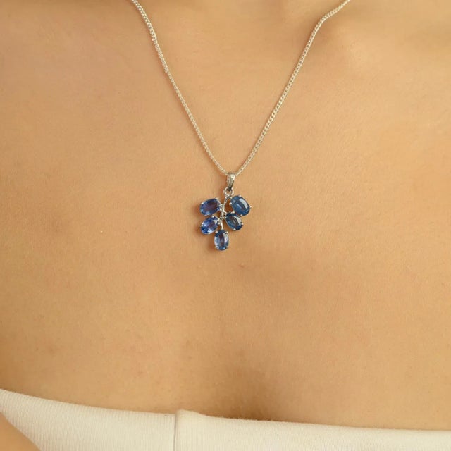 This stunning pendant is crafted from 925 sterling silver and features five oval-cut blue sapphires with a total weight of...