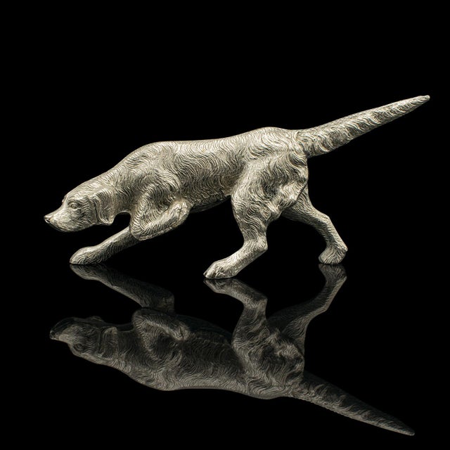 This is an antique dog figure. An English, nickelled cast iron pointer hound ornament, dating to the Edwardian period,...