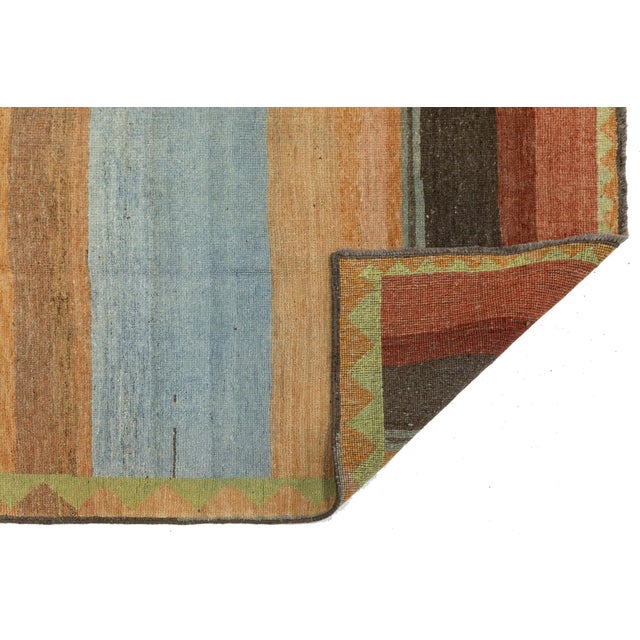 This Modern Gabbeh area rug features a minimalist striped design that blends nomadic tradition with contemporary style....