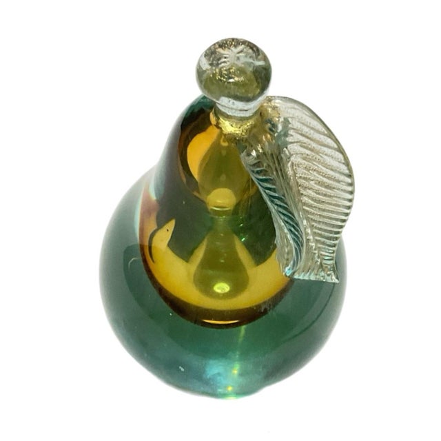 Created using the Sommerso technique to create the layered color effect. A vibrant aqua with an amber or gold-colored...