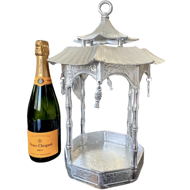 A sculptural pagoda lantern in substantial cast aluminum, distinguished by a two-tier roof, upswept eaves, and small...