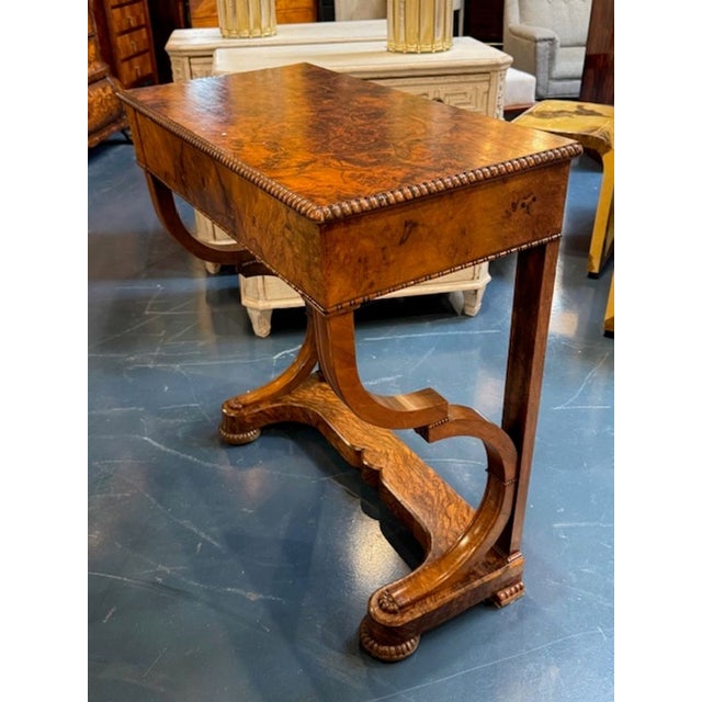 This product is a stunning 19th century Burl Walnut Biedermeier console. This elegant piece of furniture features a finish...