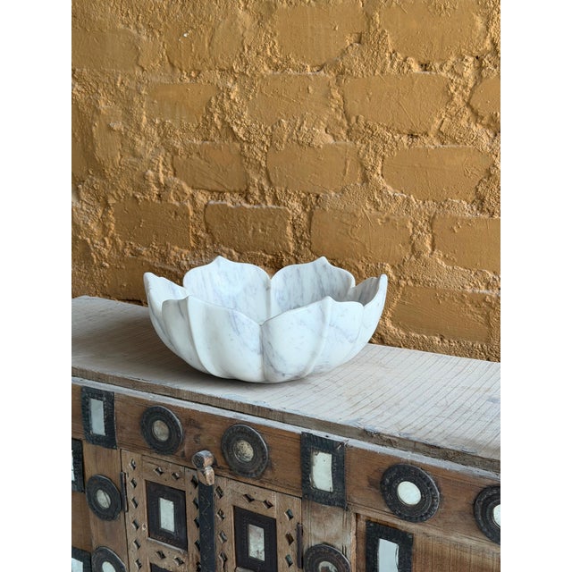 This hand-carved white marble vessel sink features a beautifully sculpted flower-inspired design, bringing a refined and...