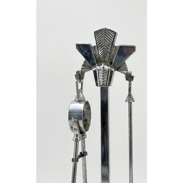 Art Deco chrome fireplace tool set, circa 1925-1935. Two matching stands with the full suite of tools (poker, brush,...