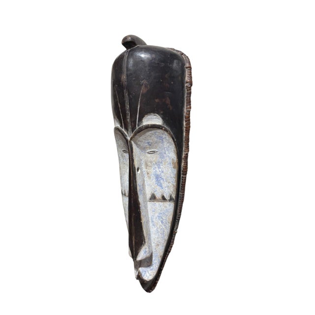 Superb vintage Fang mask carved from a single piece of heavy wood, featuring an elongated heart-shaped face rendered in...