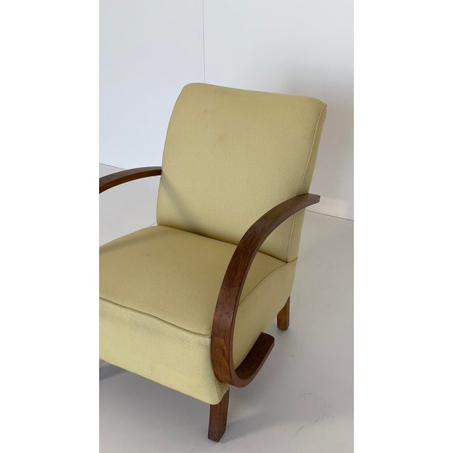 Comfortable club chair with curved armrests made of dark-stained oak. Simple and stylish, the understated design blends...