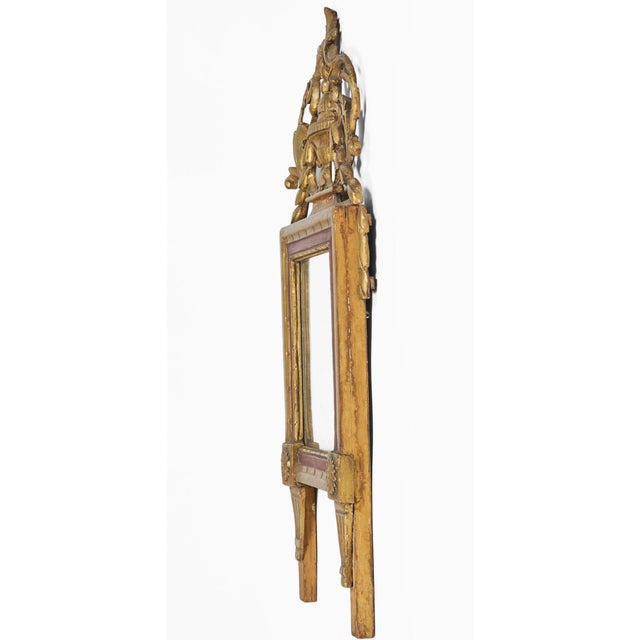 French Louis XVI period giltwood mirror with a hand carved crest of a carved vase centered by scrolling acanthus leaves...