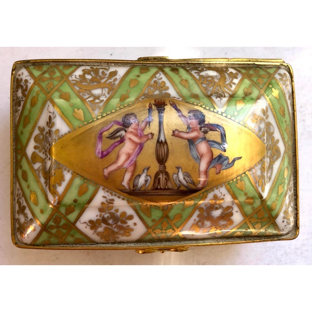 Domed top is hinged and decorated with two putties. Overall hatched basket weave design in green and gold. Front and sides...