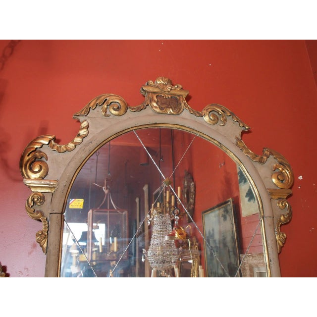 A beautiful 19th Century Italian wall mirror painted in a pale gray. Shaped like an arched window the top is all carved...
