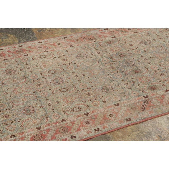 Handwoven in wool, circa 1920–1940, this antique 4x15 Persian Malayer runner features a delicate all-over floral geometric...