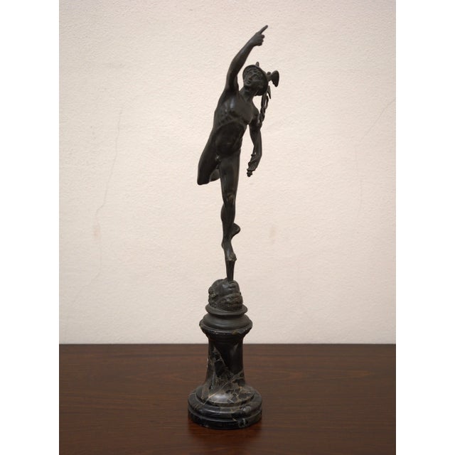 An elegant 19th-century bronze statue of Mercury, modeled after the famous Giambologna model, represents a god in dynamic...