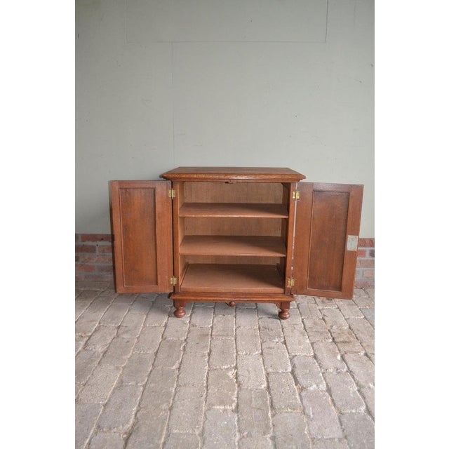 19th century Dutch oak cabinet. The height is 69 cm. The width is 61 cm. The depth is 42 cm. Shelves behind the two doors....