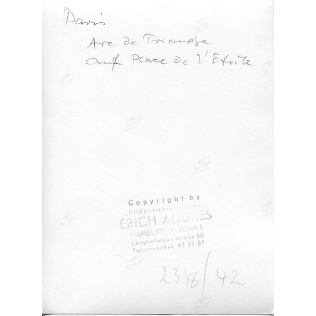 This is a black-and-white photograph of the Arc de Triomphe in Paris, France, taken in 1952. The image shows the...