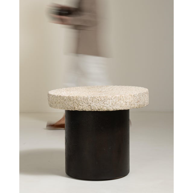 An early 20th century side table combining a wrought iron base with a stone top, reflecting the design vocabulary shared...