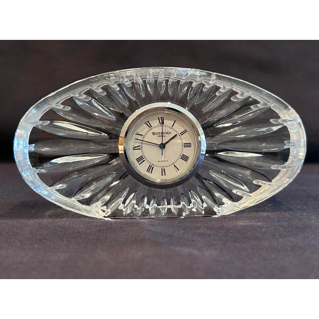 Elegant clear crystal with sunburst facet cuts. Oval shape. Classic round clock insert with Roman numerals. Shimmering...
