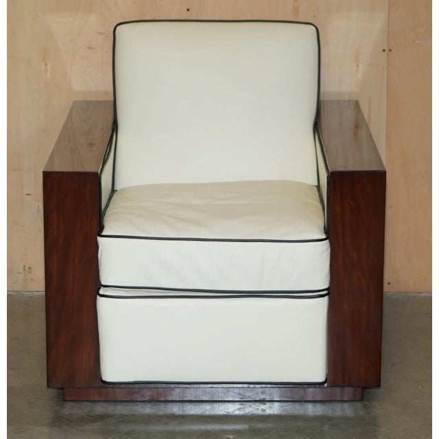 Exposed mahogany wood lends striking style to this American 1930s-inspired club chair, which is set upon a sleek plinth...