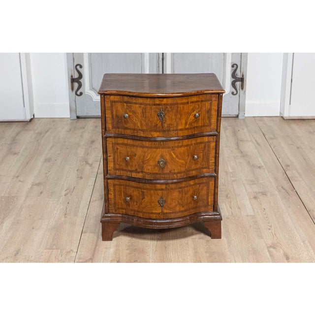 An Italian walnut and mahogany three-drawer chest from the 18th century with serpentine front, aged bronze hardware and...