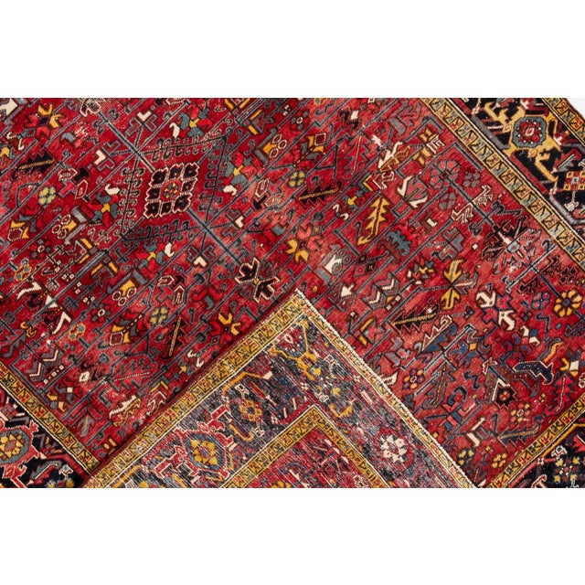 Beautiful Persian vintage Heriz hand-knotted wool rug with a red field. This piece has multicolor accents in an all-over...