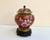 Ornate cloisonné lidded vase on wooden stand with a red background! China, 1970s. This charming jar has a floral design...