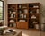 Set of Three Mid-Century Teak Bookcases. A coordinated trio of tall teak-veneer bookcases with adjustable shelves and...