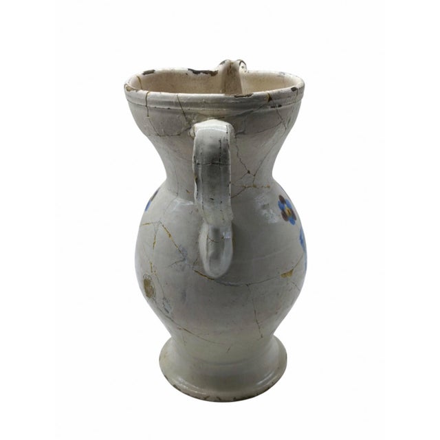 An elegant antique majolica ceramic jug, a fascinating example of Italian ceramic craftsmanship and folk tradition. The...