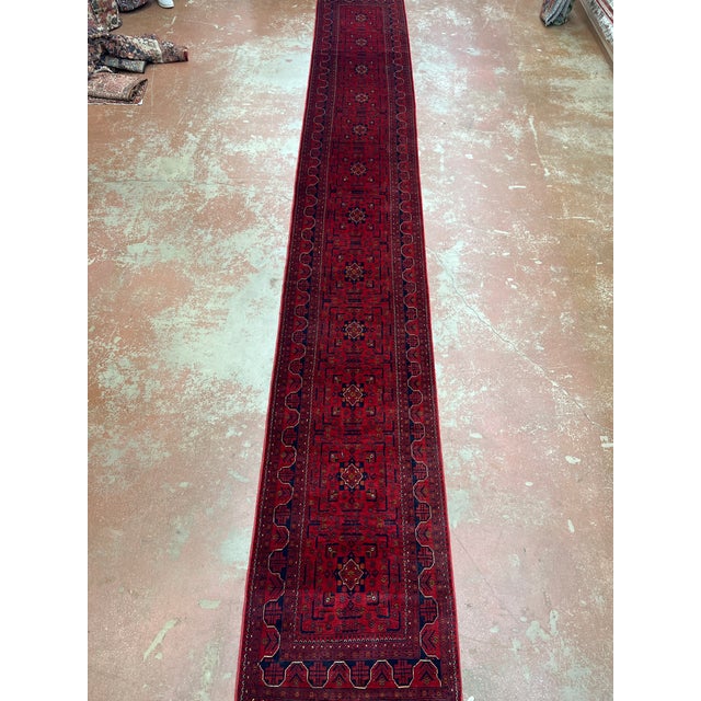 Afghan Turkmen long runner, hand knotted in Afghanistan from 100% wool. Measuring 2’9” x 19’2”, this striking runner...