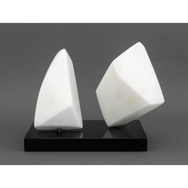 Modernist Abstract White Marble Sculpture, 1986, comprised of two carved white marble pieces mounted on a black stone...