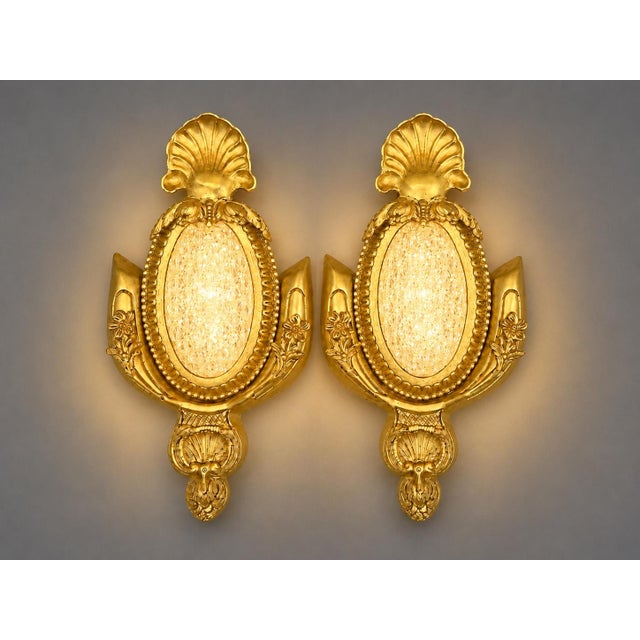 This elegant pair of 1970s French Louis XVI–style wall sconces combines finely detailed bronze craftsmanship with a warm...
