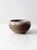 A vintage studio pottery bowl with a hand-crafted form, featuring an unglazed exterior and a light gray glazed interior....