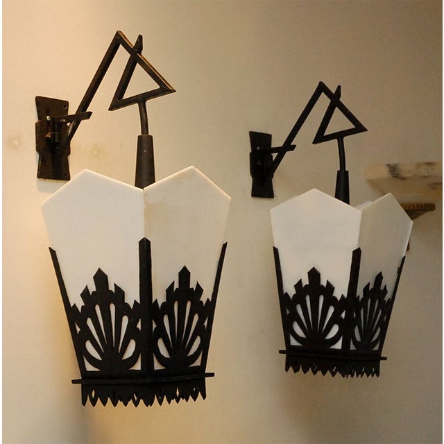 Pair of Asian-style black iron lanterns with metal cutwork and angular milk glass panels from the 1940s. Decorative...