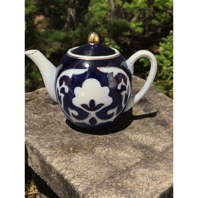 This Vintage Pakhta Blue & White Gilded Imperial Porcelain Russian Tea Pot is a stunning piece of dinnerware that exudes...