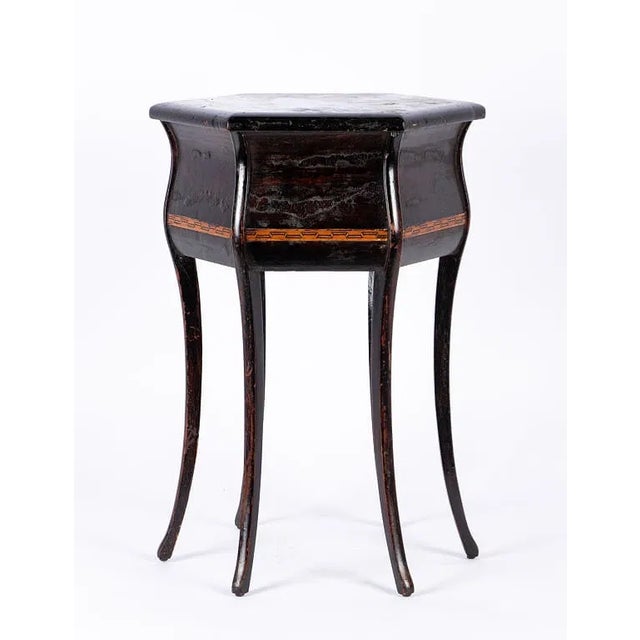 Neoclassical-style six-sided accent table featuring a rich dark brown finish and a timeless architectural silhouette. Its...