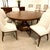 Narrow, angled strips radiate from the center of the top in a geometric wood pattern. The effect is quiet. Warm brown oak...