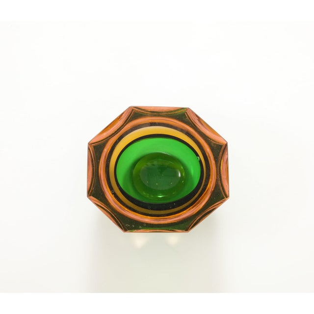 Crafted in the vibrant spirit of the 1960s, this Murano glass ashtray exudes timeless charm. With its ocgtagonal shape and...